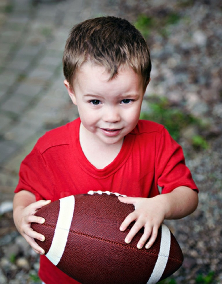 Boy Clutching American Football - © Shsphotography